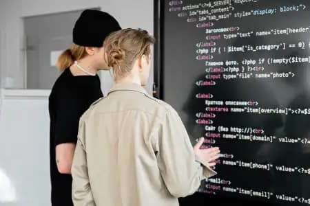 Two people reviewing some computer code